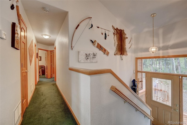 hallway with dark colored carpet