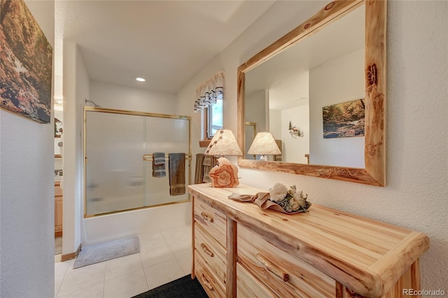 bathroom featuring combined bath / shower with glass door, vanity, and tile patterned flooring