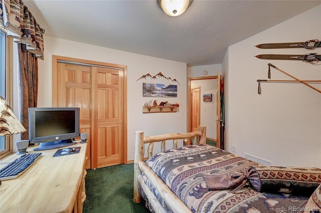 bedroom featuring a textured ceiling, carpet floors, a closet, and ceiling fan