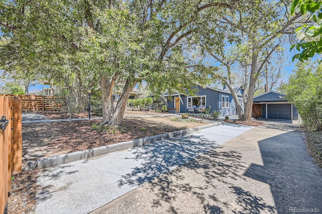 view of front of house featuring fence and an outdoor structure