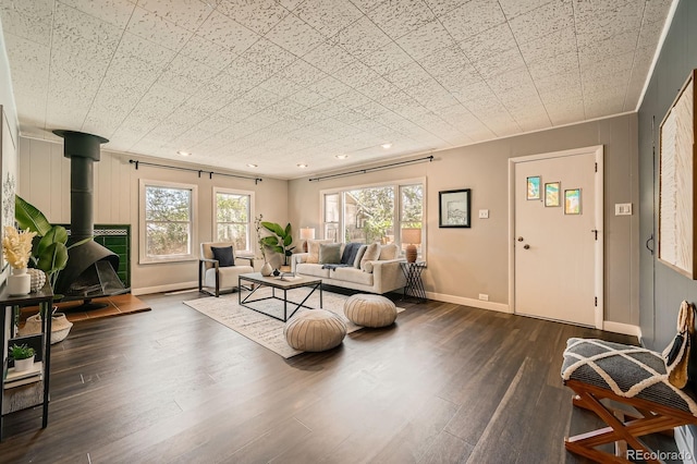 living room with a wood stove, healthy amount of natural light, dark wood finished floors, and recessed lighting