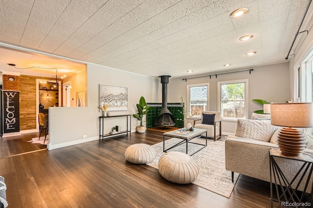 living area with a wood stove, wood finished floors, baseboards, wood walls, and recessed lighting