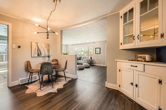 dining room featuring a chandelier, dark wood-style floors, and baseboards