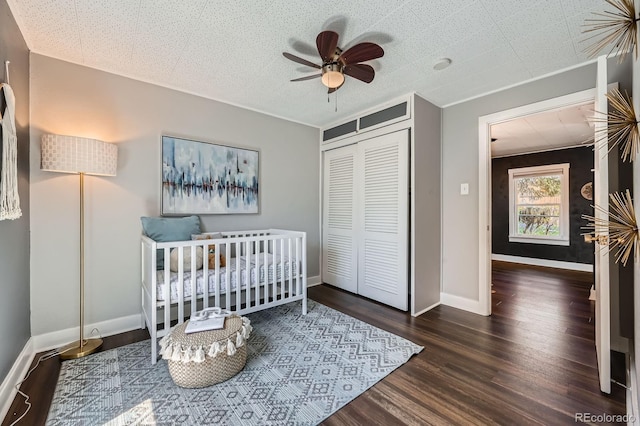 bedroom with a closet, wood finished floors, baseboards, and a ceiling fan