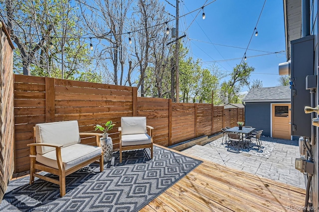 view of patio featuring a fenced backyard, outdoor dining area, and a deck