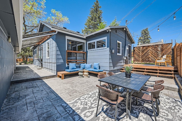 rear view of property featuring a patio, outdoor dining area, and outdoor lounge area