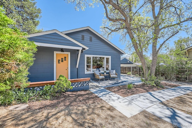 view of front of house featuring fence and a patio