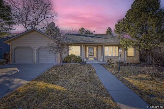 ranch-style house featuring a garage, concrete driveway, and brick siding