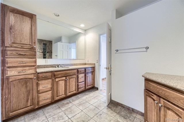 bathroom with recessed lighting, vanity, and baseboards