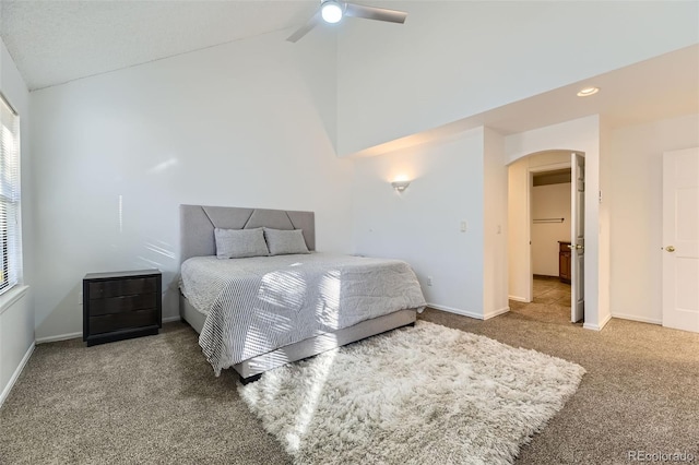 carpeted bedroom with arched walkways, high vaulted ceiling, a ceiling fan, and baseboards