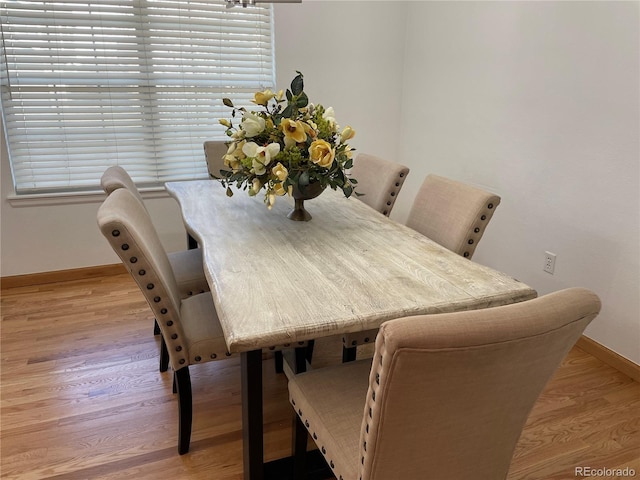 dining area featuring light wood-type flooring and baseboards