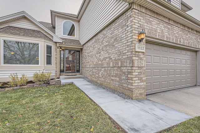 entrance to property featuring a yard and a garage