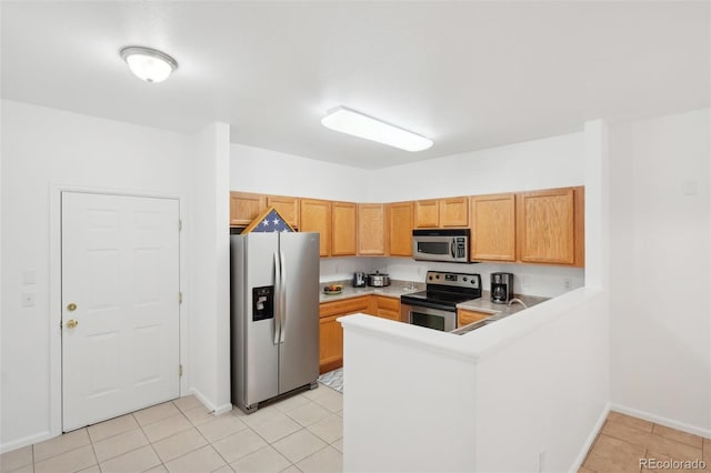 2502 S Bahama Cir Unit B, Aurora, CO 80013 - kitchen featuring stainless steel appliances, a peninsula, light countertops, baseboards, and light tile patterned floors