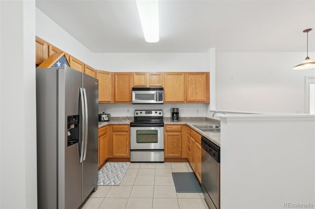 2502 S Bahama Cir Unit B, Aurora, CO 80013 - kitchen with appliances with stainless steel finishes, light tile patterned floors, a sink, light countertops, and hanging light fixtures