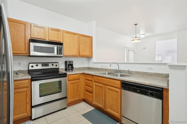 2502 S Bahama Cir Unit B, Aurora, CO 80013 - kitchen featuring appliances with stainless steel finishes, a sink, light tile patterned floors, light countertops, and decorative light fixtures