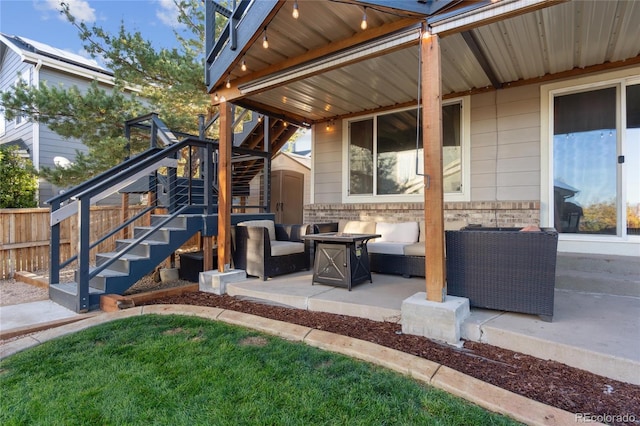 view of patio with stairway and an outdoor living space with a fire pit