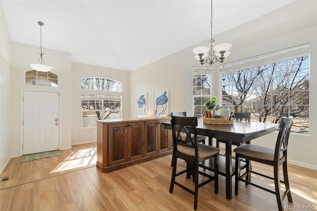 dining space featuring light wood-style floors, vaulted ceiling, and plenty of natural light