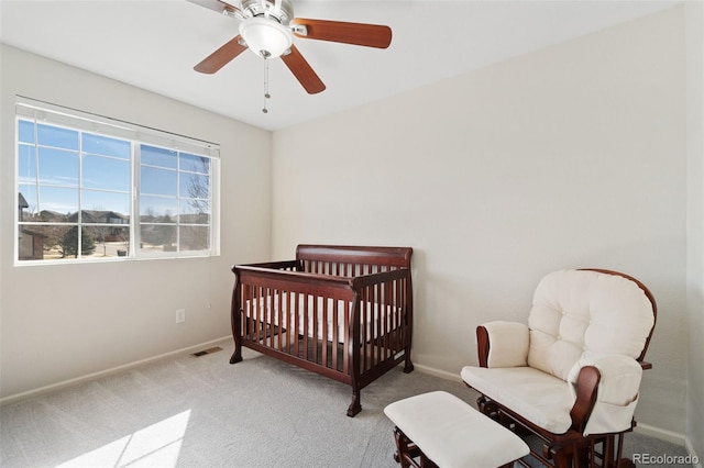 bedroom with light carpet, ceiling fan, visible vents, and baseboards