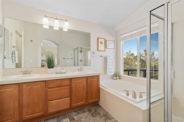 bathroom with a garden tub, a sink, a shower stall, and double vanity