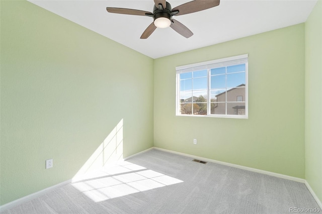 unfurnished room featuring light carpet, baseboards, visible vents, and a ceiling fan