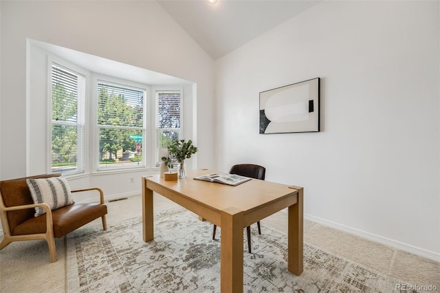 carpeted office featuring lofted ceiling