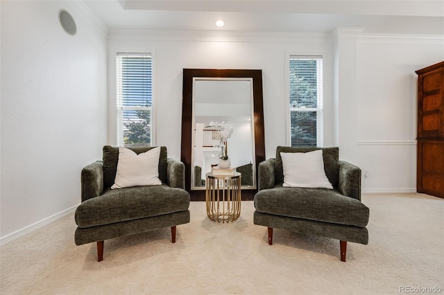 living area with crown molding and light colored carpet