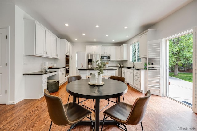 dining space with sink and light wood-type flooring