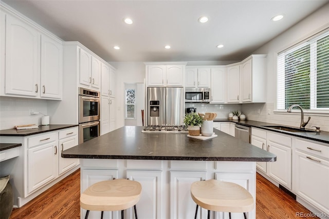 kitchen featuring sink, a kitchen breakfast bar, a center island, and appliances with stainless steel finishes