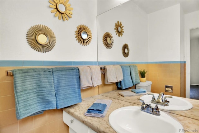 400 S Hoyt St, Lakewood, CO 80226 - bathroom with tile walls, toilet, vanity, and a wainscoted wall