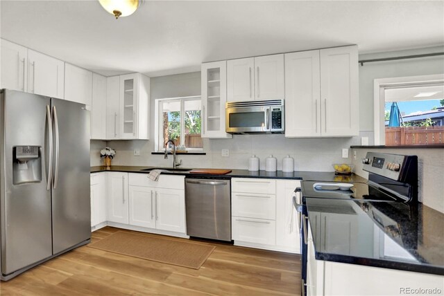 400 S Hoyt St, Lakewood, CO 80226 - kitchen featuring appliances with stainless steel finishes, dark countertops, tasteful backsplash, and light wood-style floors
