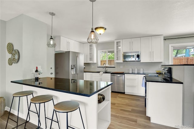 400 S Hoyt St, Lakewood, CO 80226 - kitchen featuring stainless steel appliances, a peninsula, dark countertops, white cabinets, and open shelves