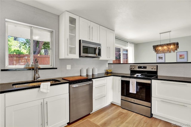 400 S Hoyt St, Lakewood, CO 80226 - kitchen featuring stainless steel appliances, a sink, dark countertops, and white cabinets
