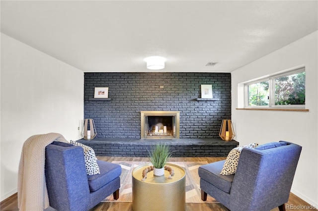 400 S Hoyt St, Lakewood, CO 80226 - living area featuring wood finished floors, brick wall, and a fireplace