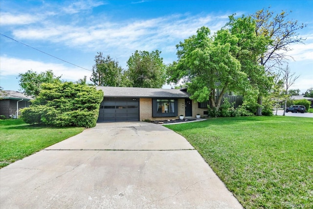 400 S Hoyt St, Lakewood, CO 80226 - view of front of house featuring a garage, concrete driveway, a front lawn, and brick siding