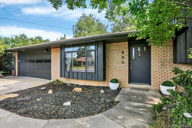 400 S Hoyt St, Lakewood, CO 80226 - view of front of property featuring brick siding, an attached garage, and driveway