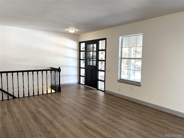 entrance foyer with dark hardwood / wood-style floors and a textured ceiling