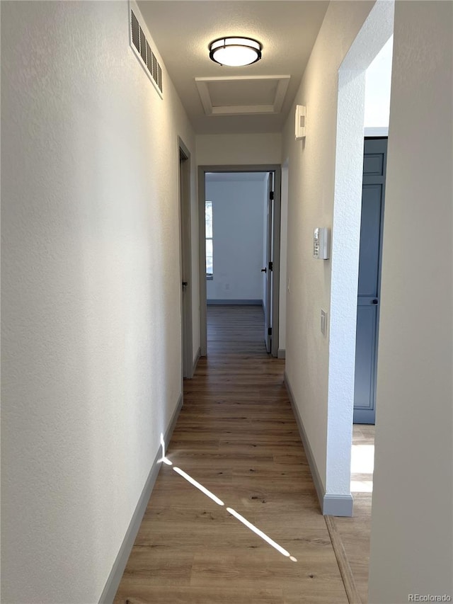 hall featuring hardwood / wood-style floors and a tray ceiling