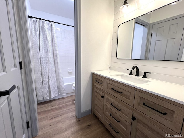 full bathroom featuring hardwood / wood-style flooring, vanity, toilet, and shower / bath combo with shower curtain