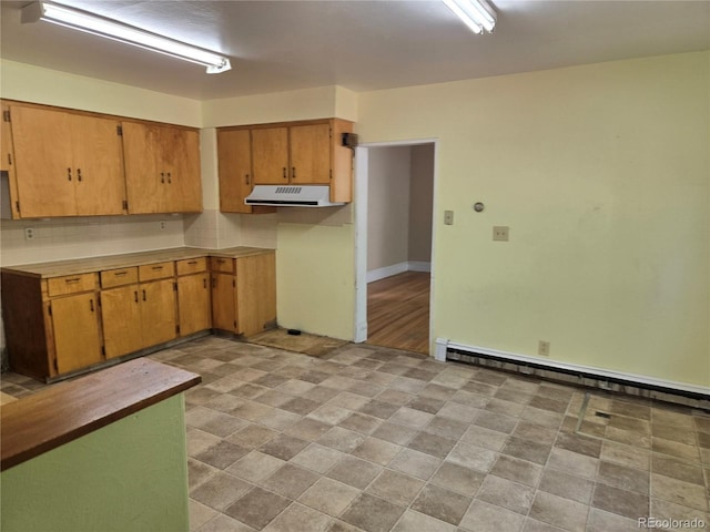 104 Joe S Chavez Dr, La Jara, CO 81140 - kitchen featuring ventilation hood, baseboard heating, light countertops, and tasteful backsplash