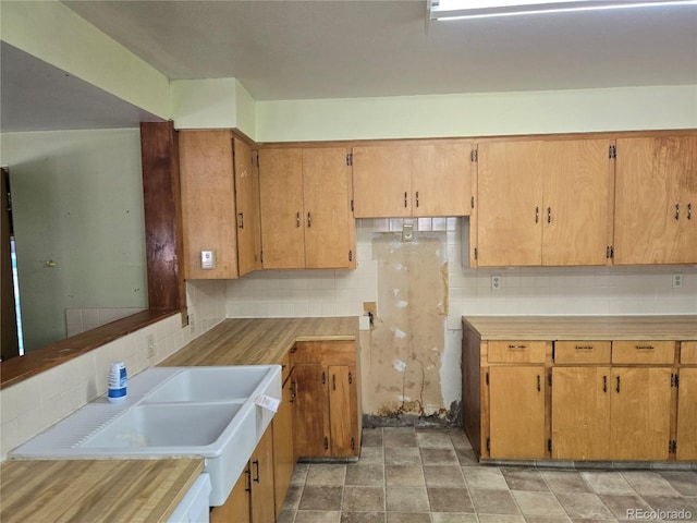 104 Joe S Chavez Dr, La Jara, CO 81140 - kitchen featuring tasteful backsplash, light countertops, and brown cabinets