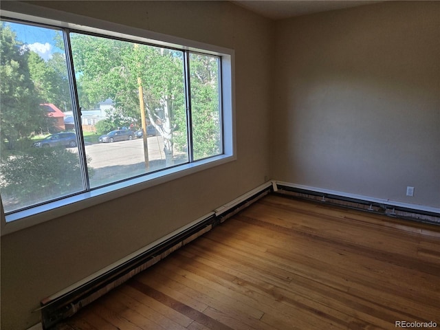 104 Joe S Chavez Dr, La Jara, CO 81140 - empty room featuring baseboard heating, healthy amount of natural light, and hardwood / wood-style flooring