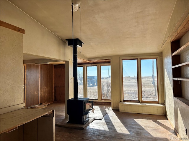 unfurnished sunroom featuring a wood stove