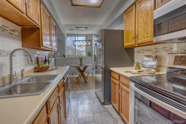 kitchen featuring light tile patterned flooring, appliances with stainless steel finishes, tasteful backsplash, and sink