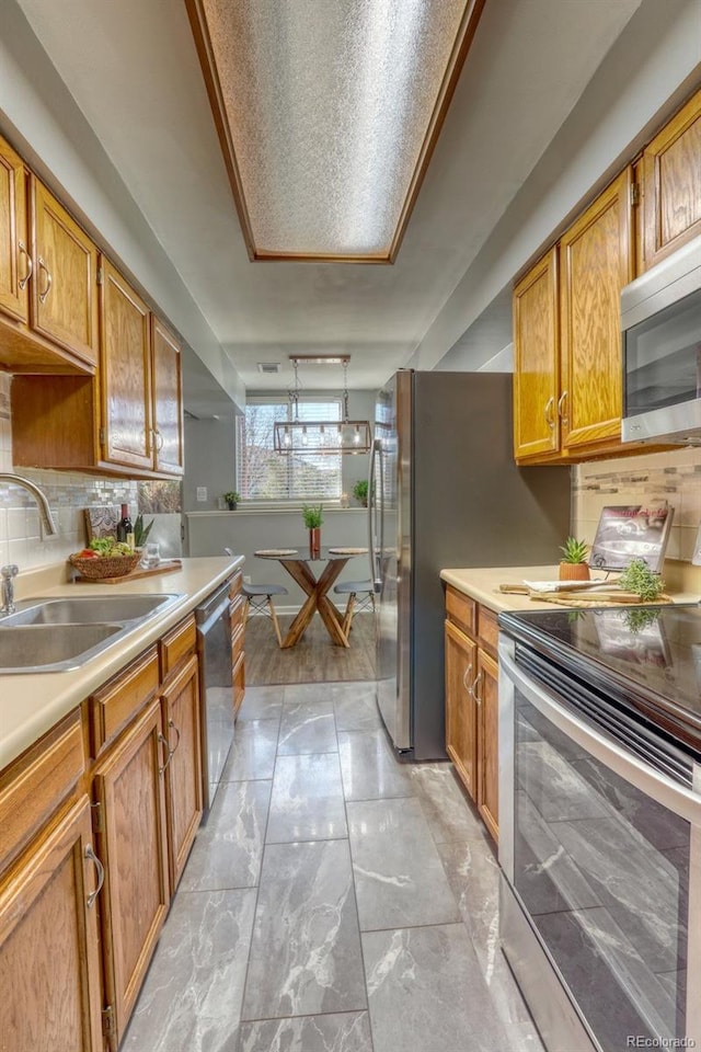 kitchen featuring decorative backsplash, sink, and appliances with stainless steel finishes