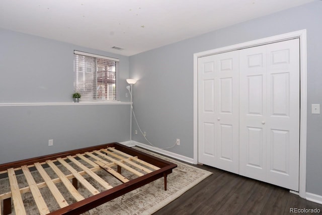 unfurnished bedroom with dark wood-type flooring and a closet