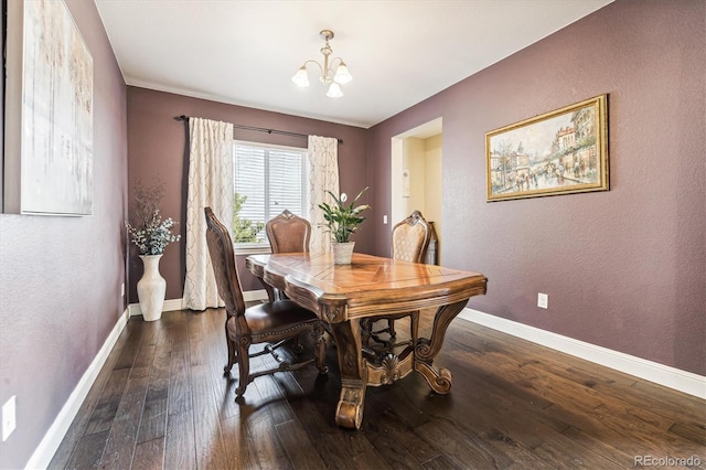 dining room with dark hardwood / wood-style flooring and an inviting chandelier