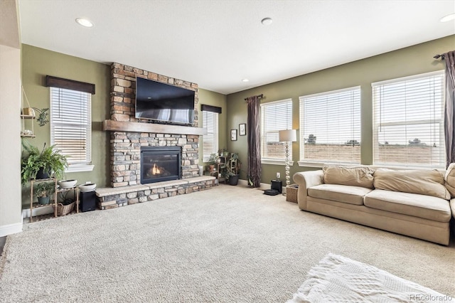 living room featuring a stone fireplace and carpet