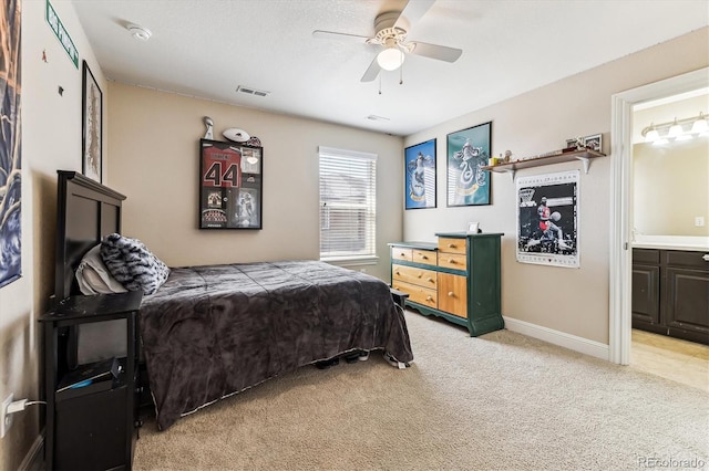 bedroom with ensuite bathroom, carpet floors, and ceiling fan