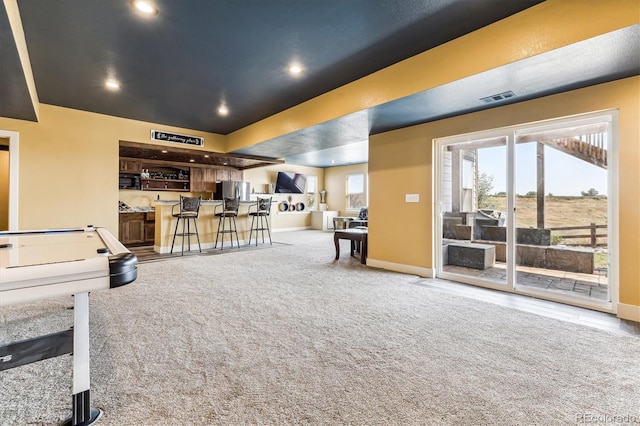 playroom featuring indoor bar, a raised ceiling, and carpet