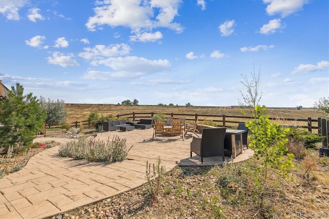 view of yard with a rural view, a patio area, and a fire pit